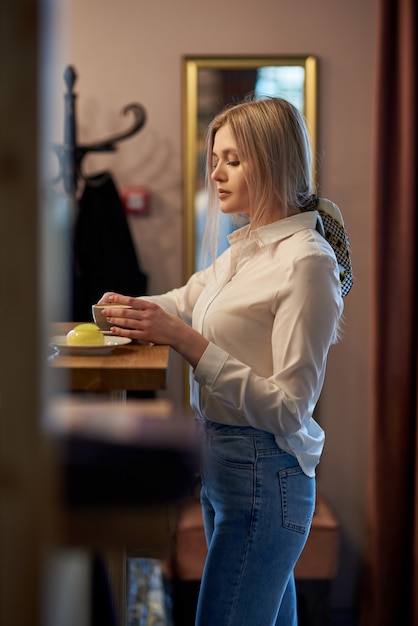 Hermosa chica está bebiendo café en la mesa de café. Retrato emocional,