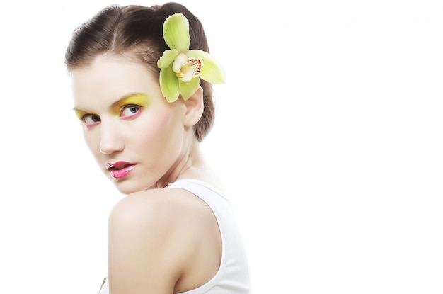 Foto hermosa chica con estilo con orquídeas phalaenopsis en el cabello.