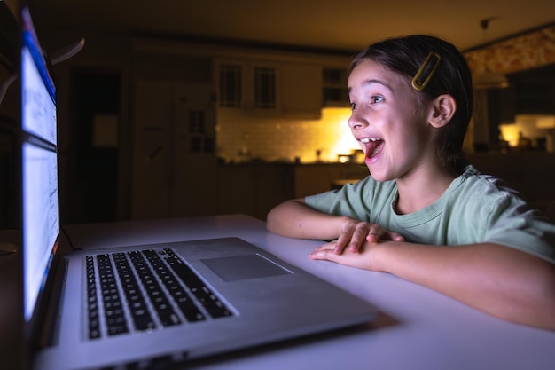 La hermosa chica estudia en la computadora por la noche tecnología y educación