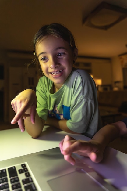La hermosa chica estudia en la computadora por la noche tecnología y educación