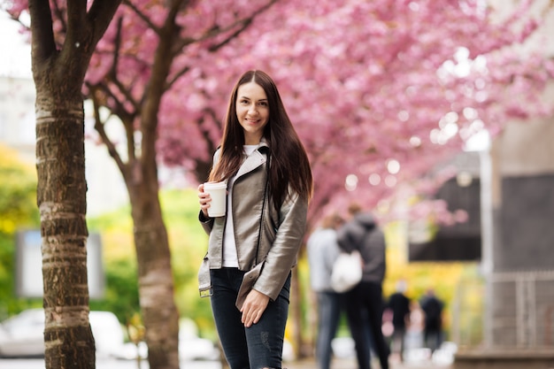 Hermosa chica europea cerca de un árbol japonés