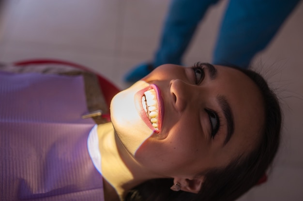 Hermosa chica en examen en odontología.