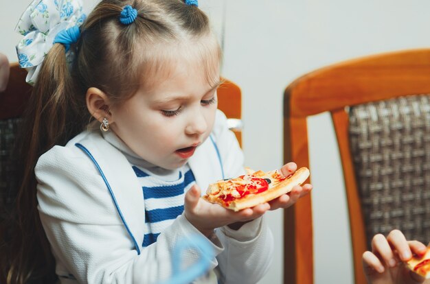 Hermosa chica en el festival comiendo una rebanada de pizza deliciosa