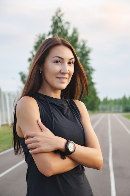 Hermosa chica fitness delgado al aire libre mirando a la cámara