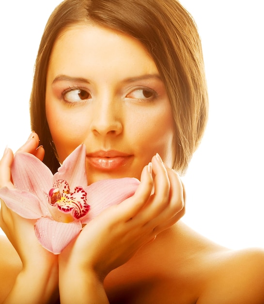 Foto hermosa chica con flor de orquídea