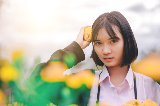 Hermosa chica con flores en el jardín