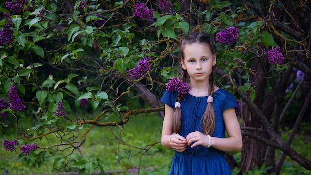 Hermosa chica con flores lilas en tristeza