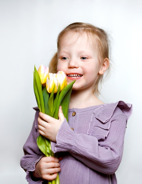 Foto hermosa chica con flores sobre un fondo blanco