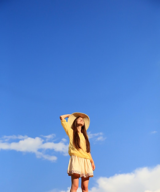 Hermosa chica en el fondo del cielo azul