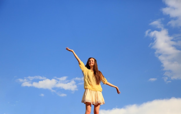 Hermosa chica en el fondo del cielo azul