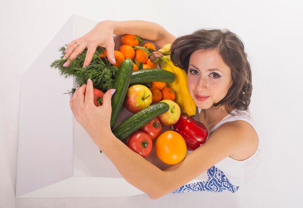 Hermosa chica con frutas y verduras frescas