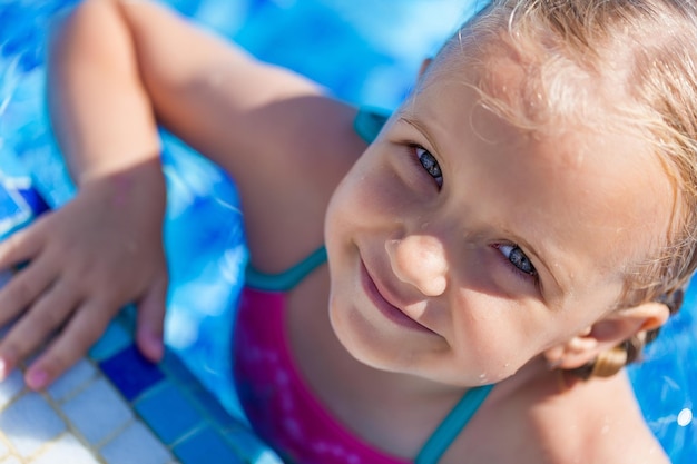 Hermosa chica con gafas de sol en la piscina en verano