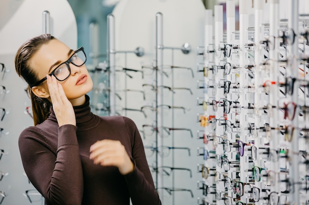 Hermosa chica con gafas en tienda óptica