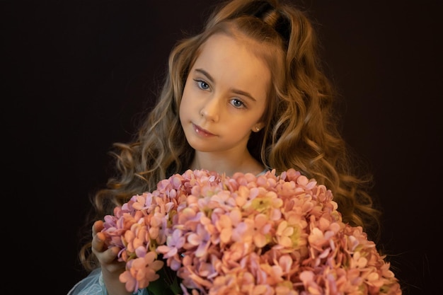 Hermosa chica con un gran ramo de hortensias