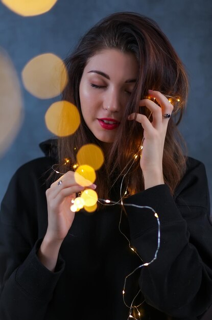 Hermosa chica con una guirnalda de Navidad