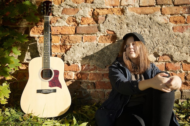 Hermosa chica con guitarra al aire libre