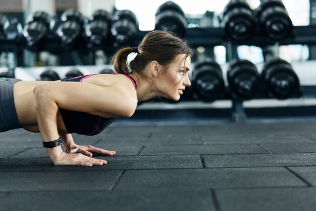 Hermosa chica haciendo deporte en el gimnasio