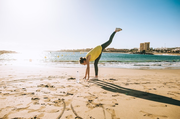 Hermosa chica haciendo deporte en la playa