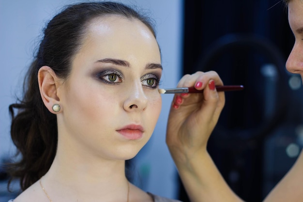 Hermosa chica haciendo maquillaje maquillador trabajo