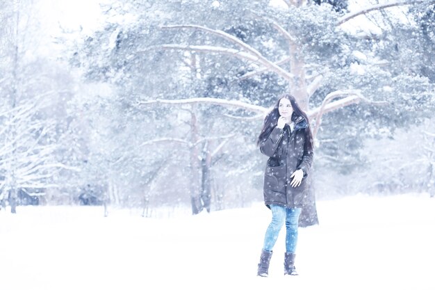 Hermosa chica en un hermoso día en el parque de nieve de invierno