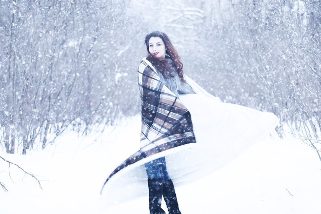 Hermosa chica en un hermoso día en el parque de nieve de invierno