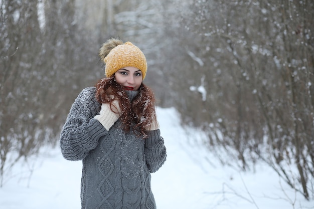 Hermosa chica en un hermoso parque de invierno para pasear