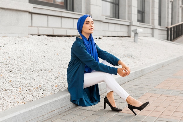 Foto hermosa chica con hijab sentada al aire libre