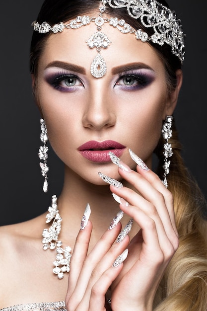 Hermosa chica en la imagen de la novia árabe con joyas caras, maquillaje oriental y manicura nupcial. La belleza del rostro. Fotos tomadas en el estudio.