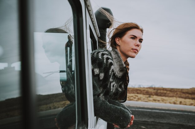 Hermosa chica islandesa disfrutando del paisaje en Islandia, mirando por la ventanilla del coche