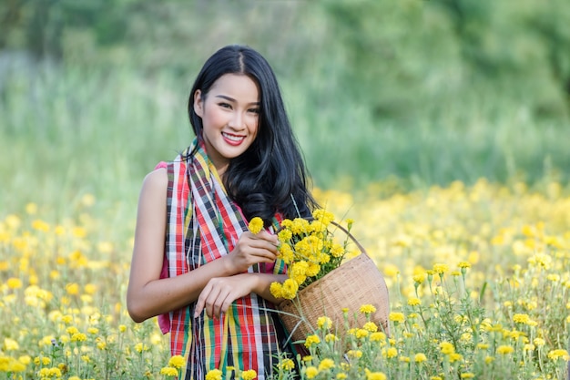 Hermosa chica jardinero asiática en campo de flores de caléndula