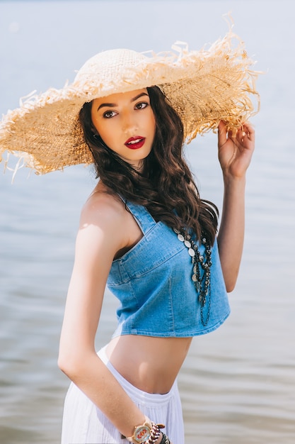 hermosa chica en el lago en gran sombrero