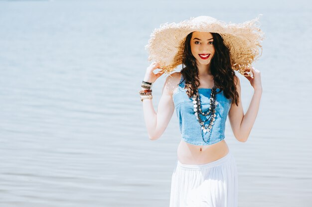 hermosa chica en el lago en gran sombrero