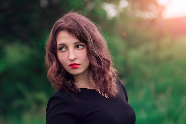 Hermosa chica con lápiz labial rojo rizado en los labios