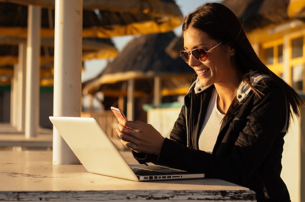 Hermosa chica leyendo un mensaje en una playa