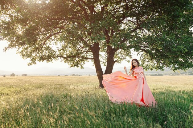 Hermosa chica libre activa sobre fondo verde al aire libre de verano