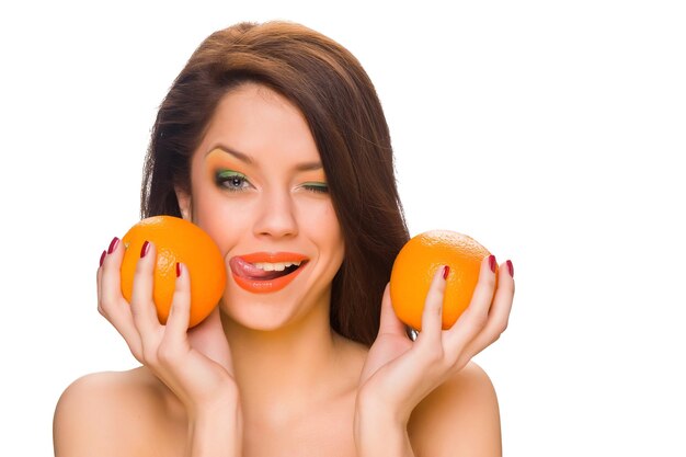 Hermosa chica con maquillaje brillante y naranjas.