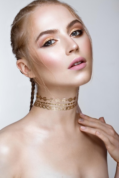 Hermosa chica con maquillaje dorado brillante y corte de pelo en la cabeza Cara de belleza