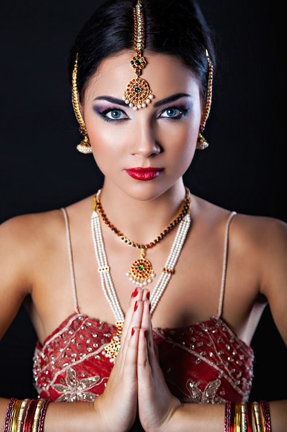 Hermosa chica con maquillaje oriental y joyería india, look de moda