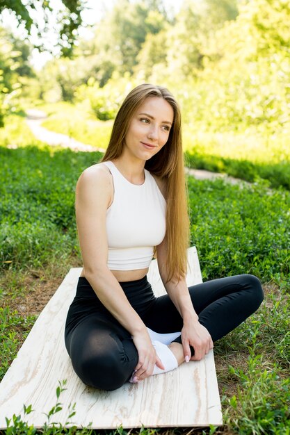 Hermosa chica medita en la naturaleza. Ella mira y sonríe fácilmente