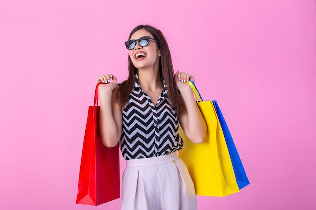 Hermosa chica con moda y gafas de sol con bolsas de compras