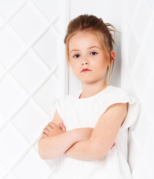 Hermosa chica de moda Linda adolescente en ropa blanca sobre fondo blanco