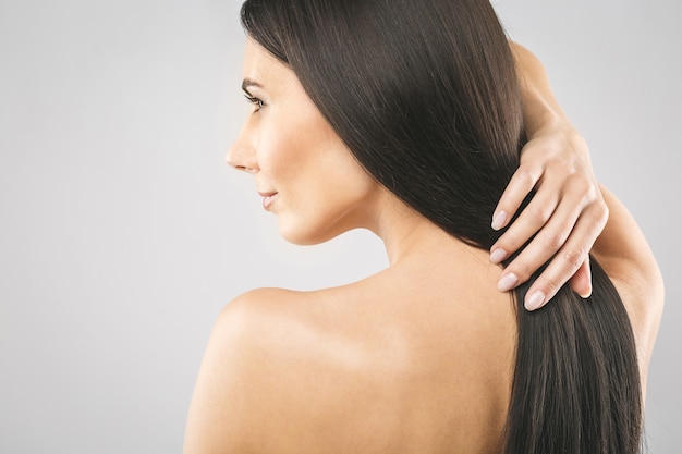 Hermosa chica morena con cabello castaño largo y recto.