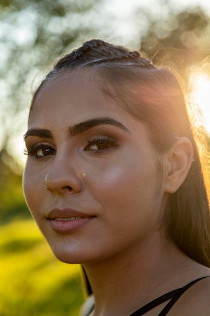 Hermosa chica morena posando en fotos en la naturaleza al atardecer