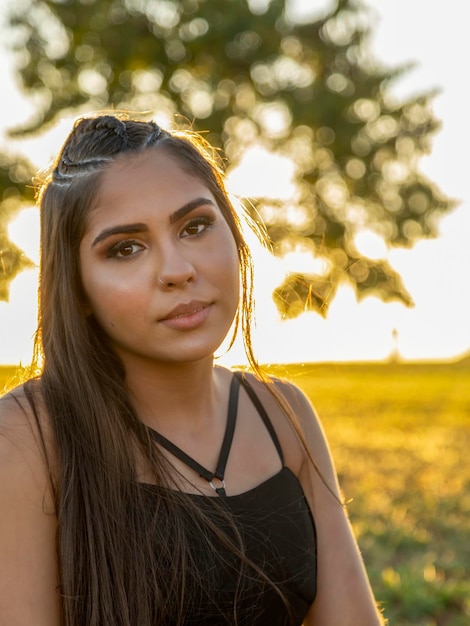 Hermosa chica morena posando en fotos en la naturaleza al atardecer