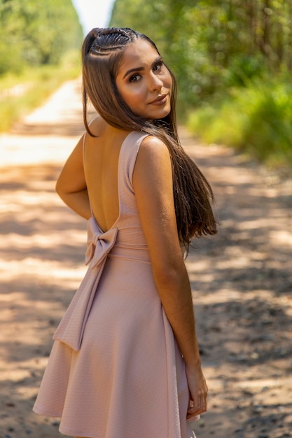 Hermosa chica morena posando en fotos en la naturaleza.