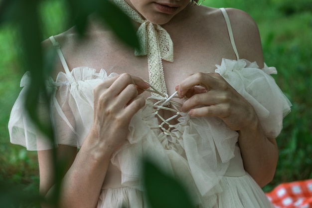 Hermosa chica en la naturaleza con un romántico vestido blanco de cerca