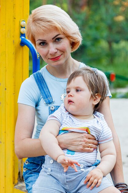 Hermosa chica con niños en un parque infantil