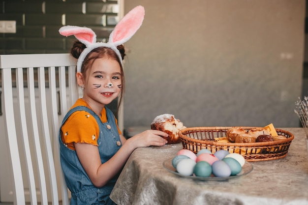 Hermosa chica en orejas de conejo pinta huevos de Pascua