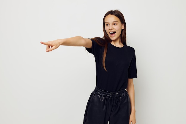 Hermosa chica en pantalones negros y una camiseta de moda de fondo aislado