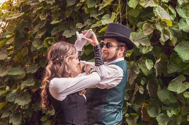 Hermosa chica con una pareja de chicos enamorados con ropa steampunk